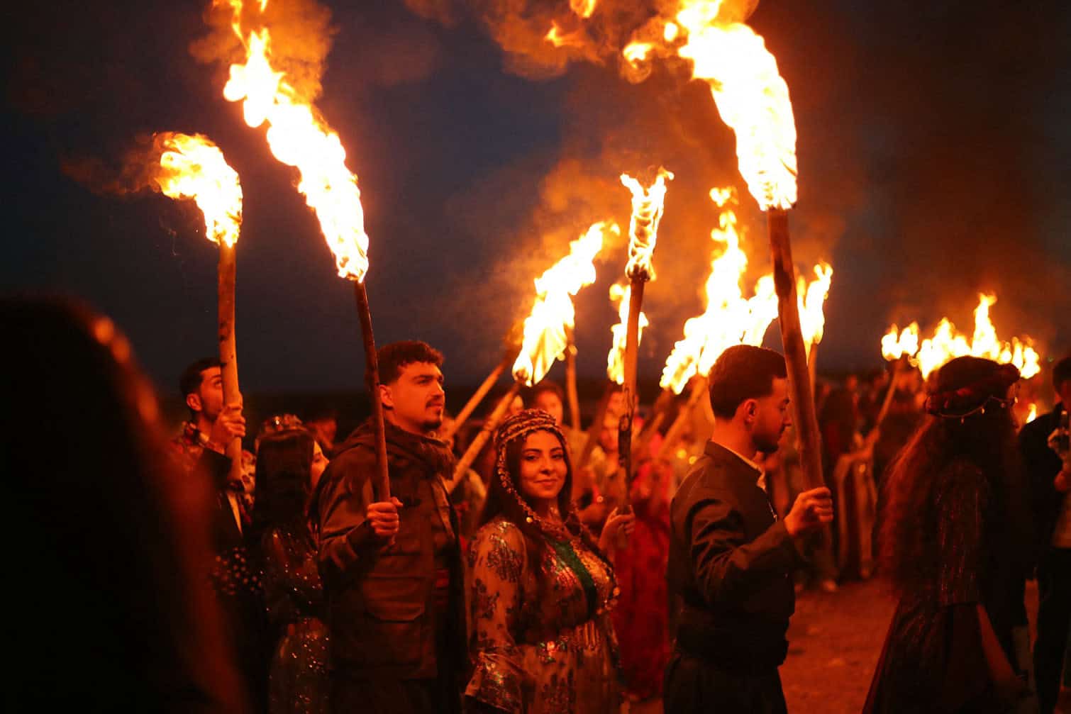 Syrian Kurds carry the flame to mark the Nowruz holiday