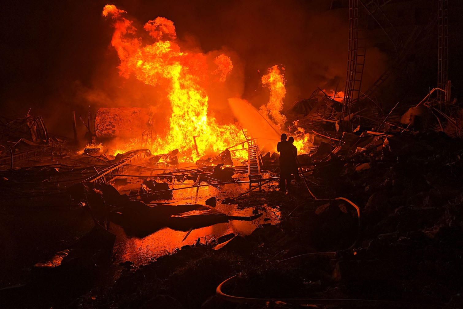 Civil defence forces attempt to extinguish a blaze