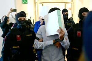 Two defendants in handcuffs are escorted to the courtroom by justice officers as a trial starts at court in Wiener Neustadt, Austria, on April 28, 2026, over a plot to attack a Taylor Swift concert in Vienna. The main suspect, who has been in detention since his arrest in August 2024, is facing terror offenses and other charges, prosecutors said. Picture via ROLAND SCHLAGER / APA / AFP) / Austria OUT
