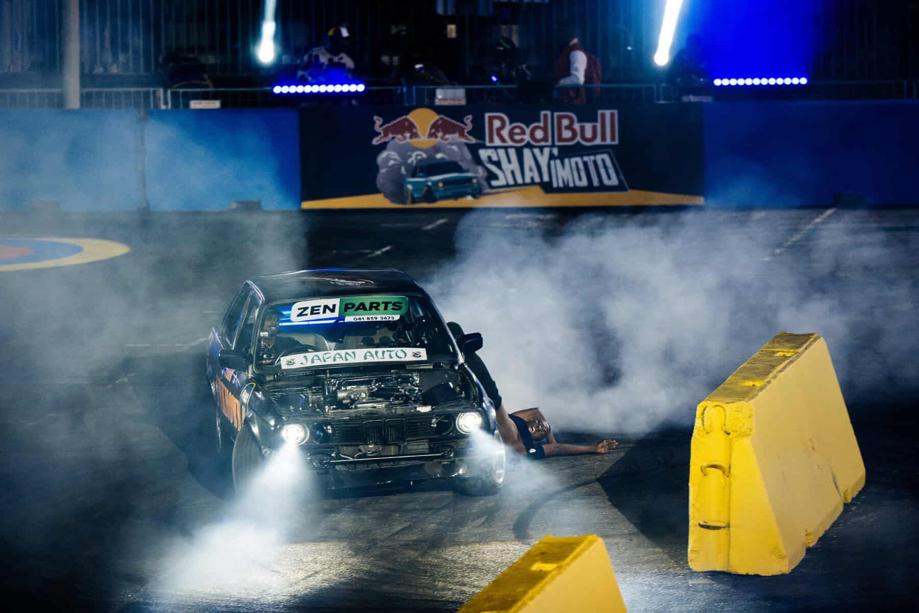 Stuntman hanging off the window of a moving car