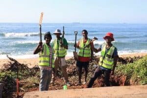 Sicelukuthela Mthembu, Phumlani Ngumede, Simphiwe Mathenjwa and Msizi Nzama preparing the foundation for a new brick and mortar staircase off the parking lot in front of the Umdloti Centre.