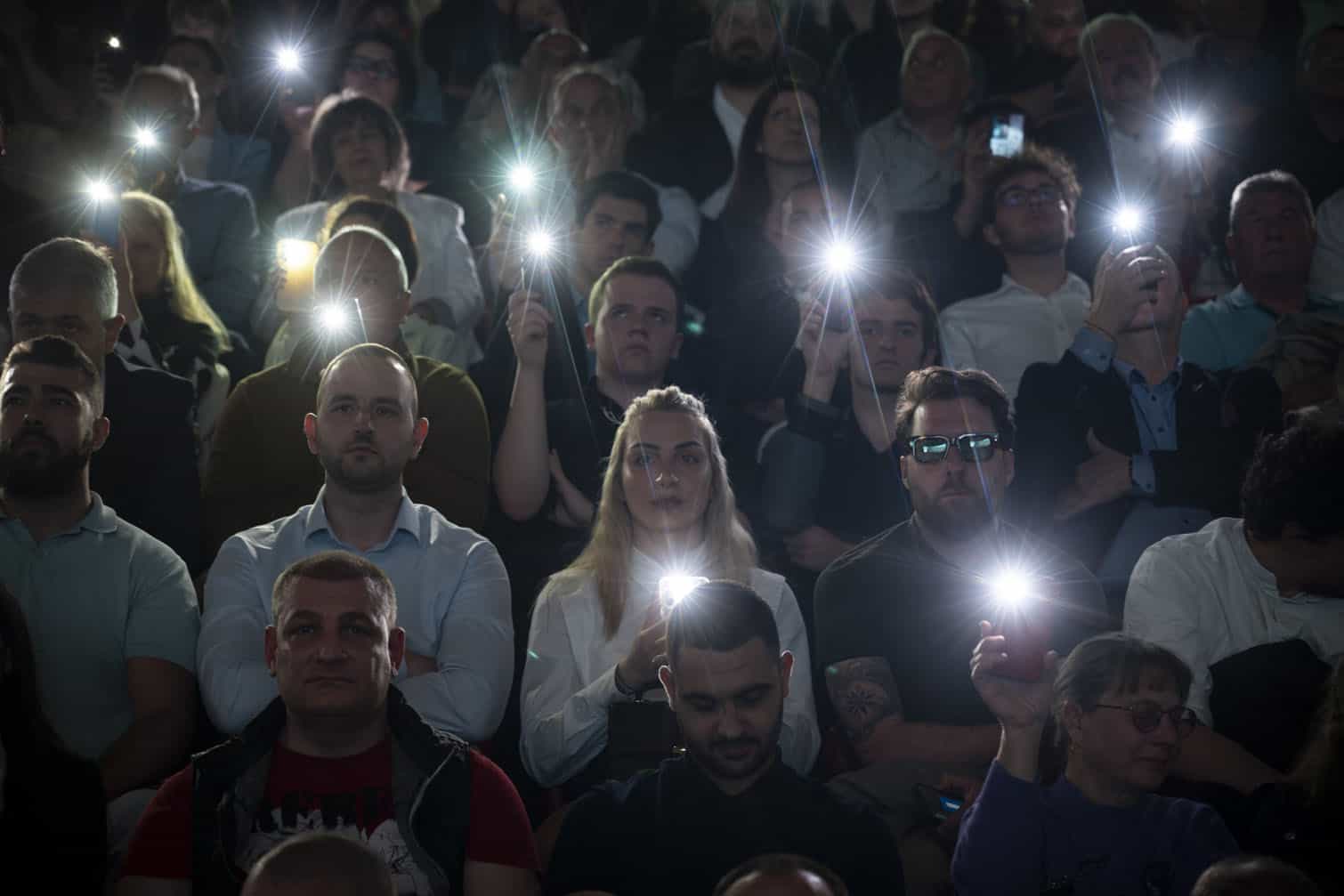 Supporters hold their mobile phones with flash lights