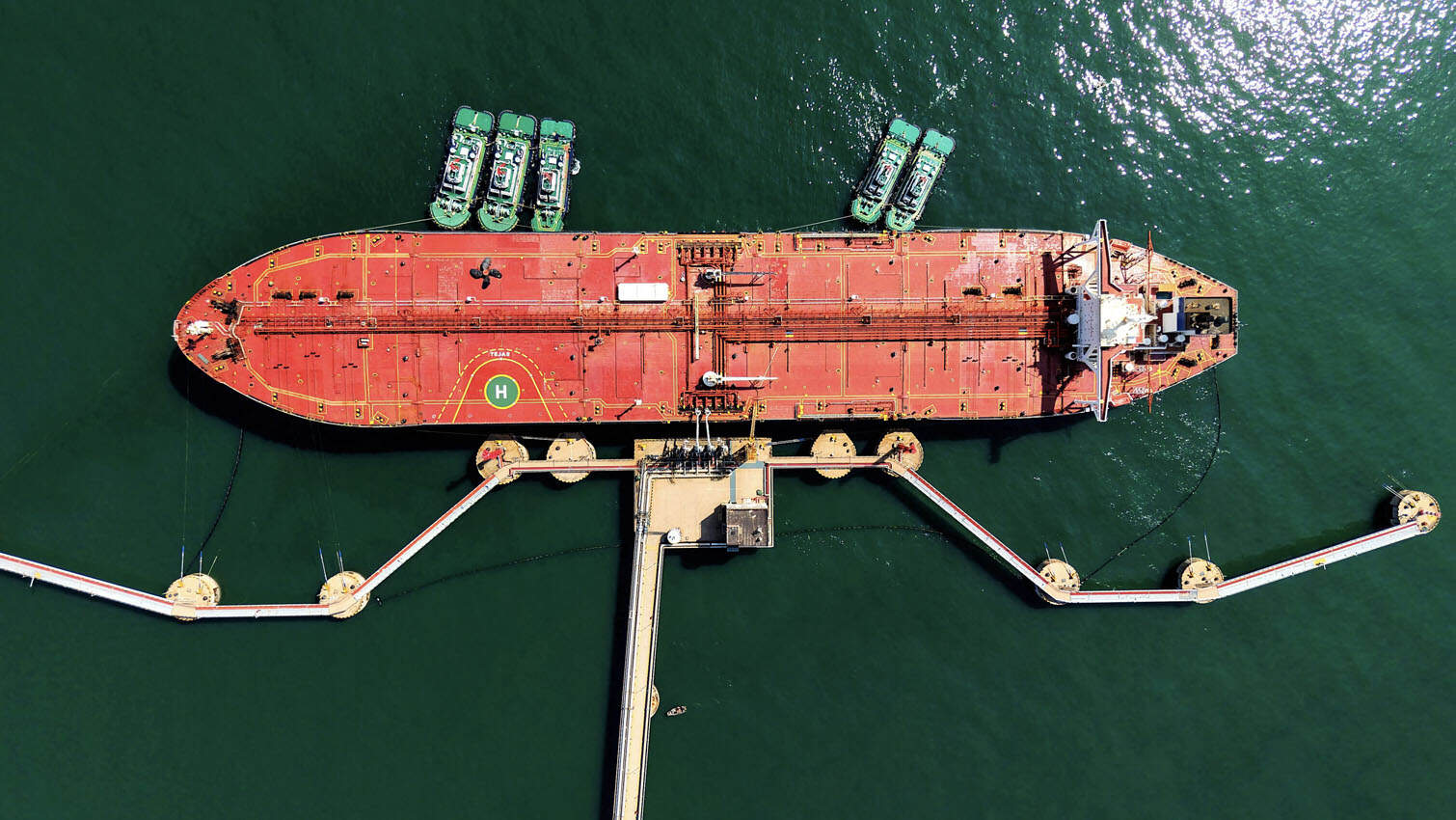An oil tanker is docked unloading crude oil