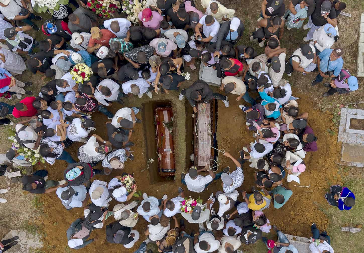Aerial view taken as people attend the mass burial of the victims of a highway bombing
