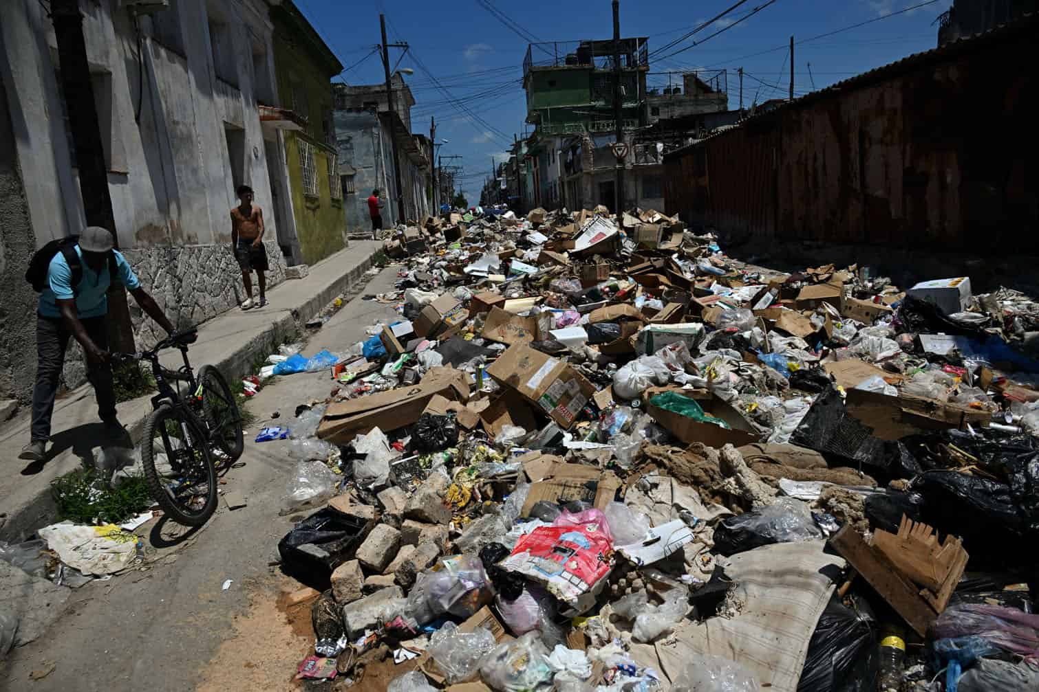 Locals walk past garbage piled up