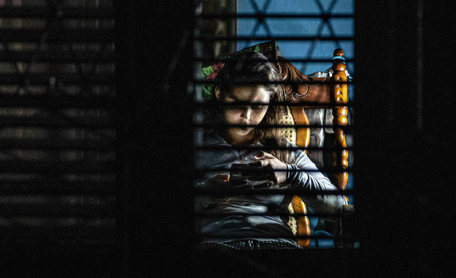 A young woman looks at her phone during a blackout