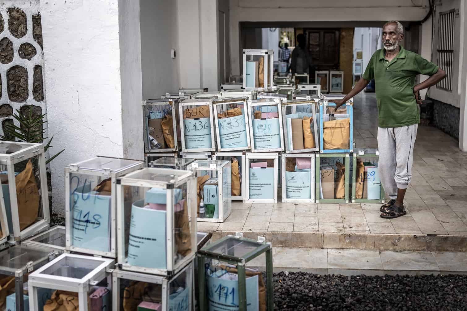 A worker takes a break next to ballot boxes