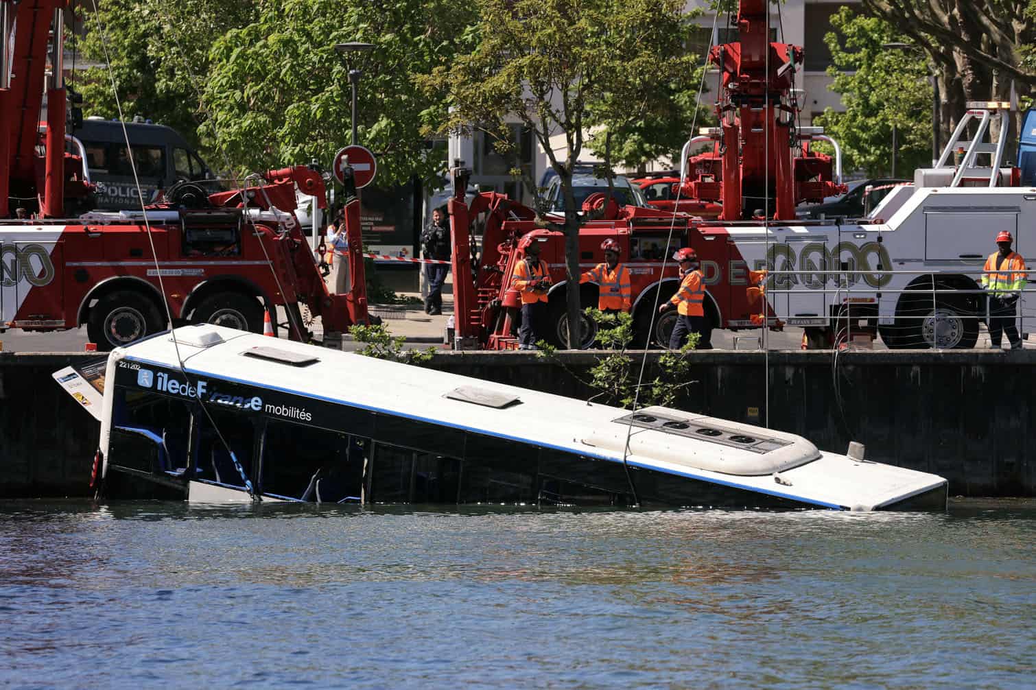 Towing teams remove a bus from the Seine river