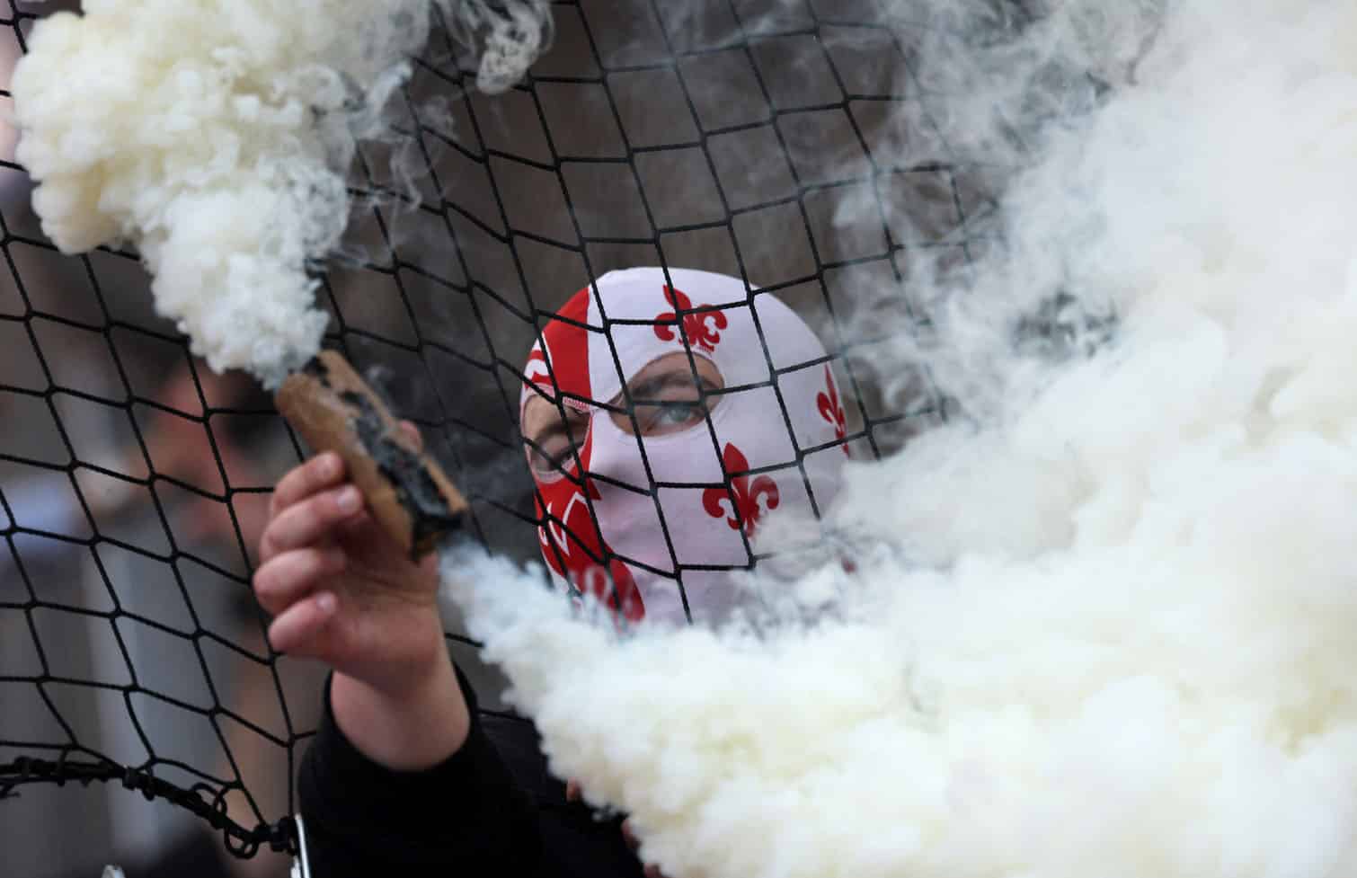 A Lille supporter holds a smoke flare