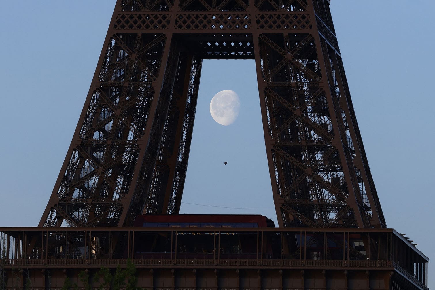 the moon behind the Eiffel Tower