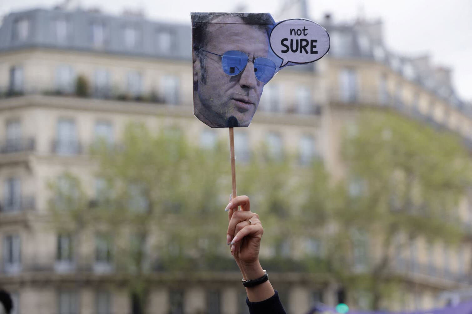 A lawyer holds a sign depicting France's President Emmanuel Macron