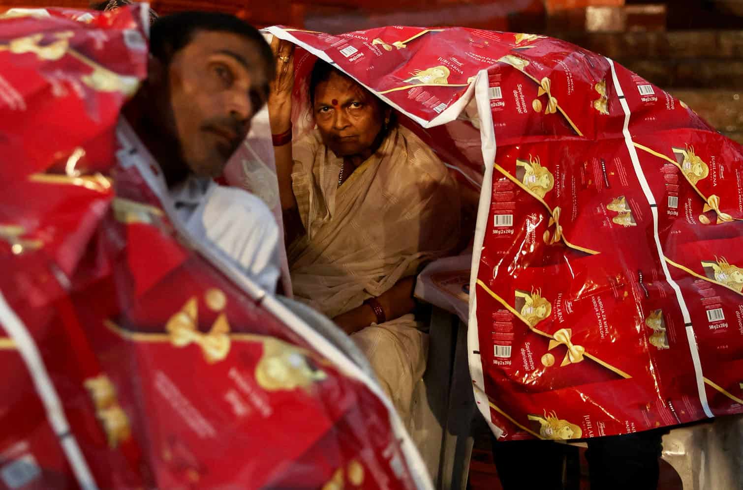 A tourist looks on as she takes shelter
