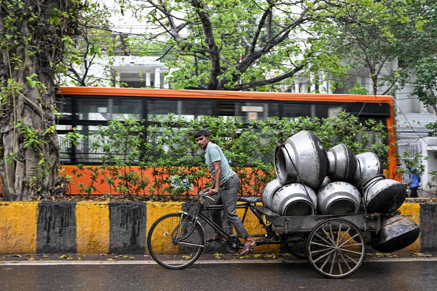 A man pulls his rickshaw cart laden with utensils