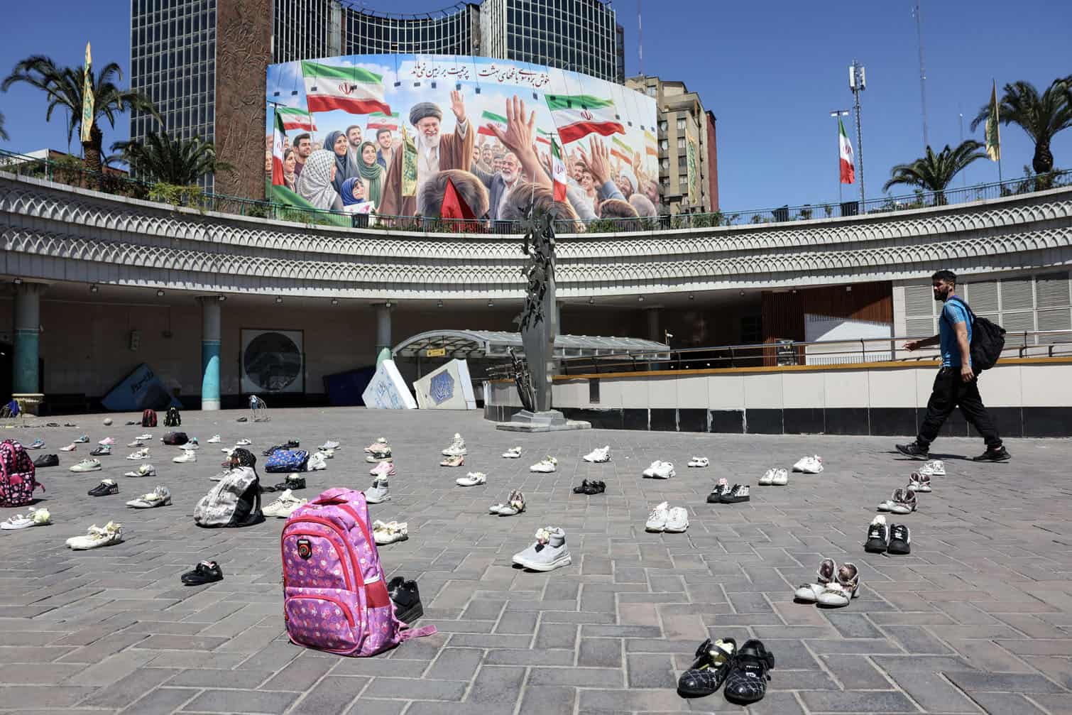 An Iranian man walks past symbolic belongings