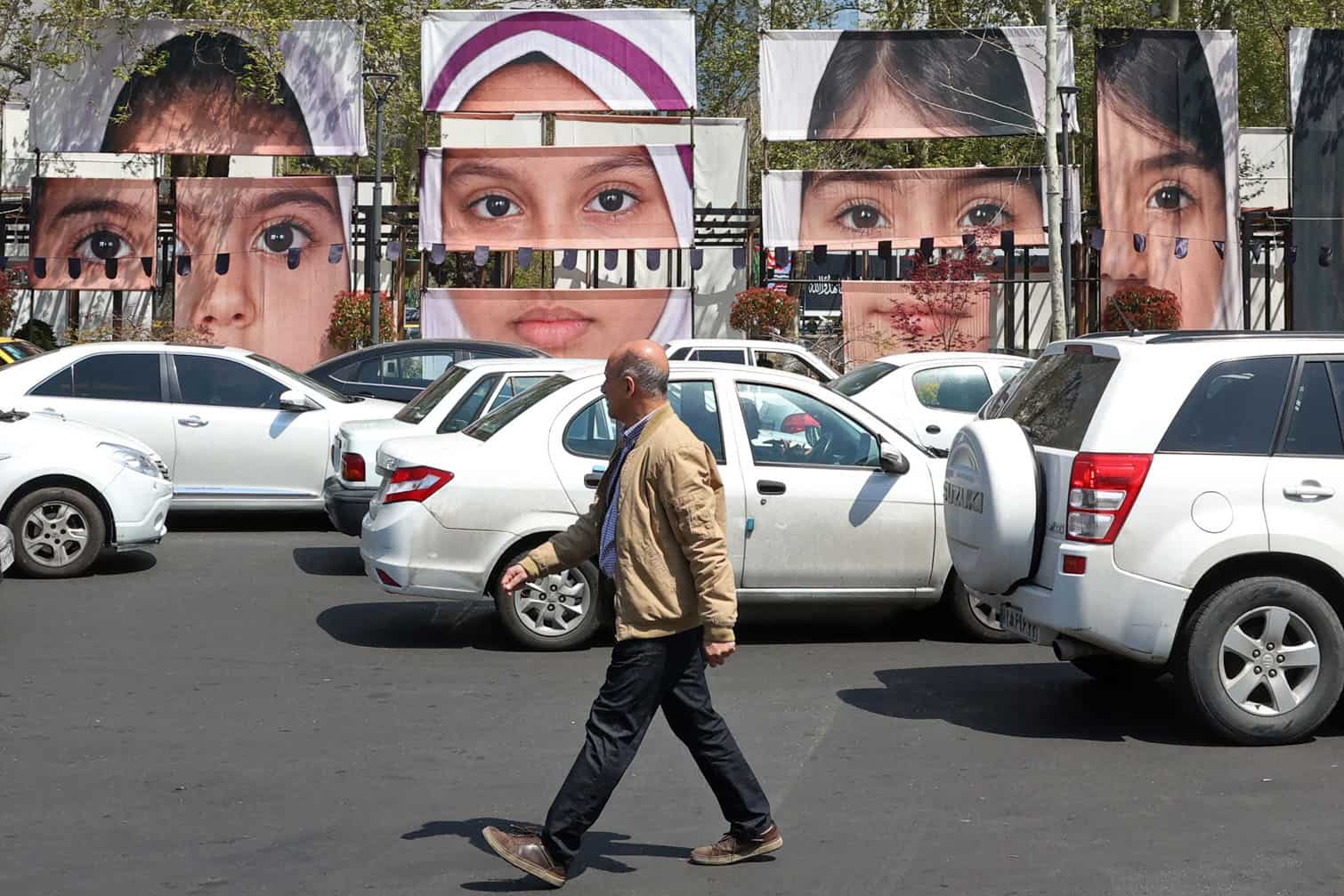 A man walks past the portraits of children killed in a deadly strike
