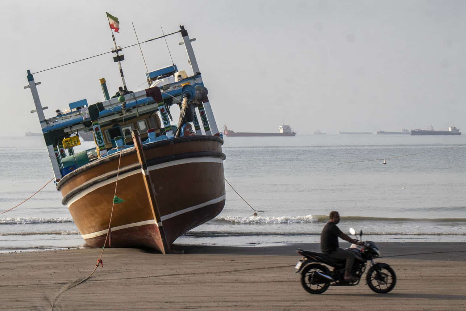 an Iranian man rides his motorcycle