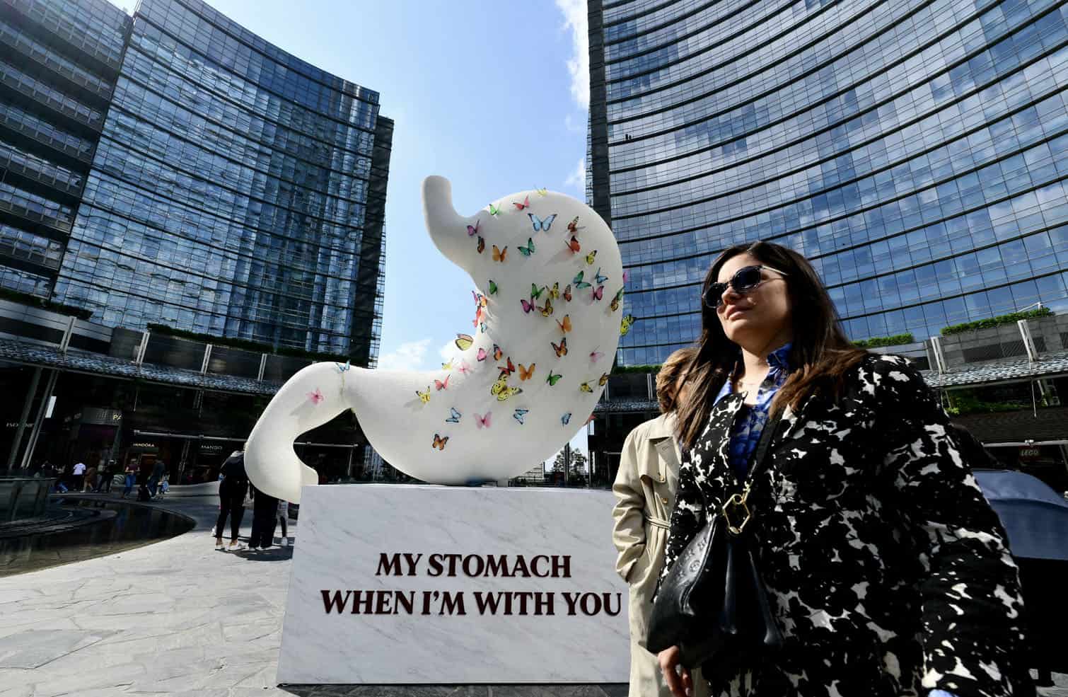 People walk past sculptures