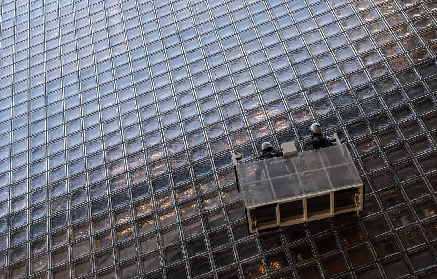 Window washers look up at a building facade