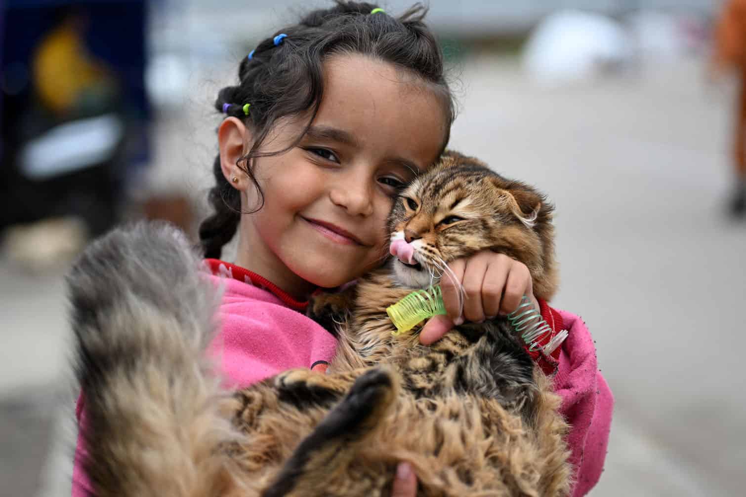 A displaced girl cuddles her cat