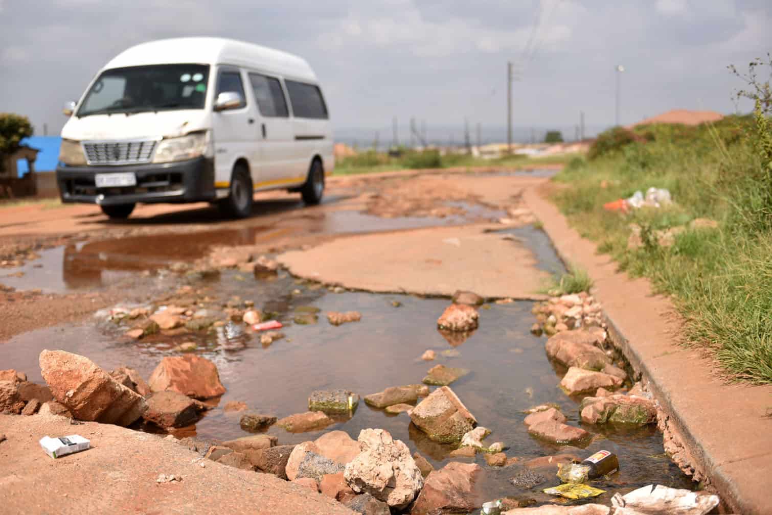 Motorists drive through damaged roads
