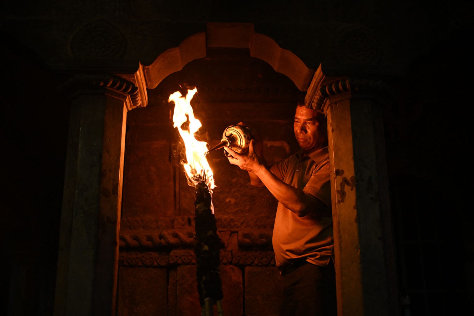 A devotee lights oil lamp during the Rato Machindranath Jatra festival