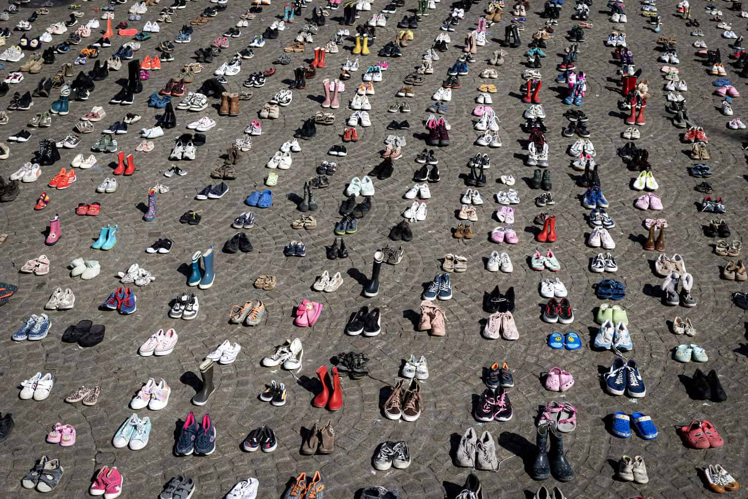 A photo shows children's shoes layed out on Dam Square