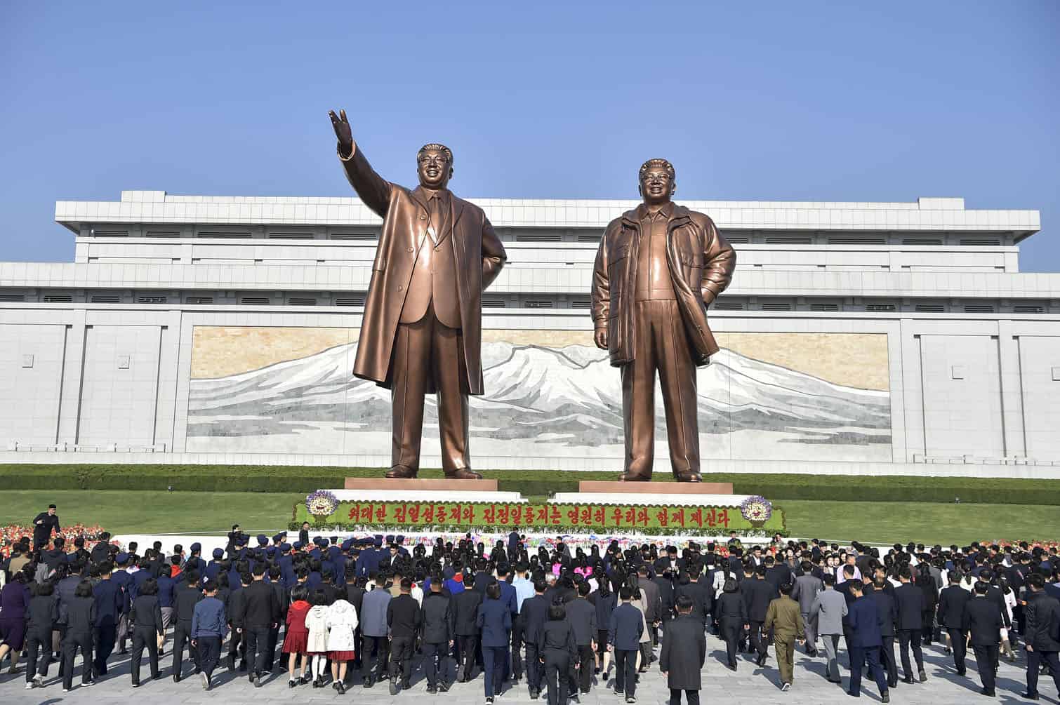 People pay tribute to the statues of late North Korean leaders