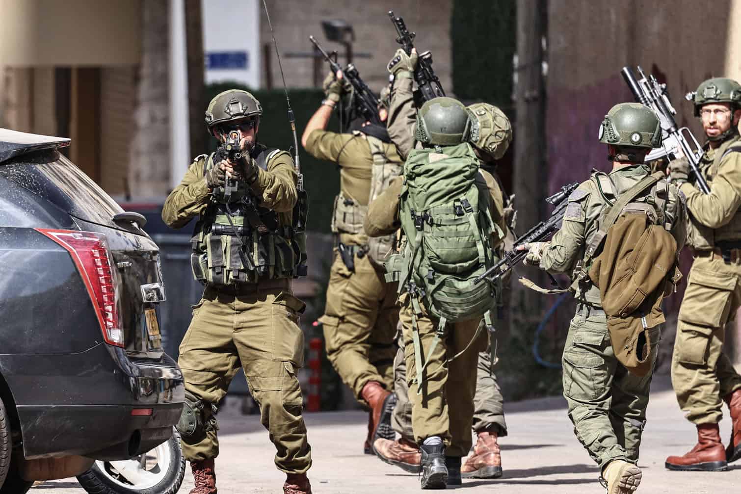 Israeli security forces point their guns during a military raid