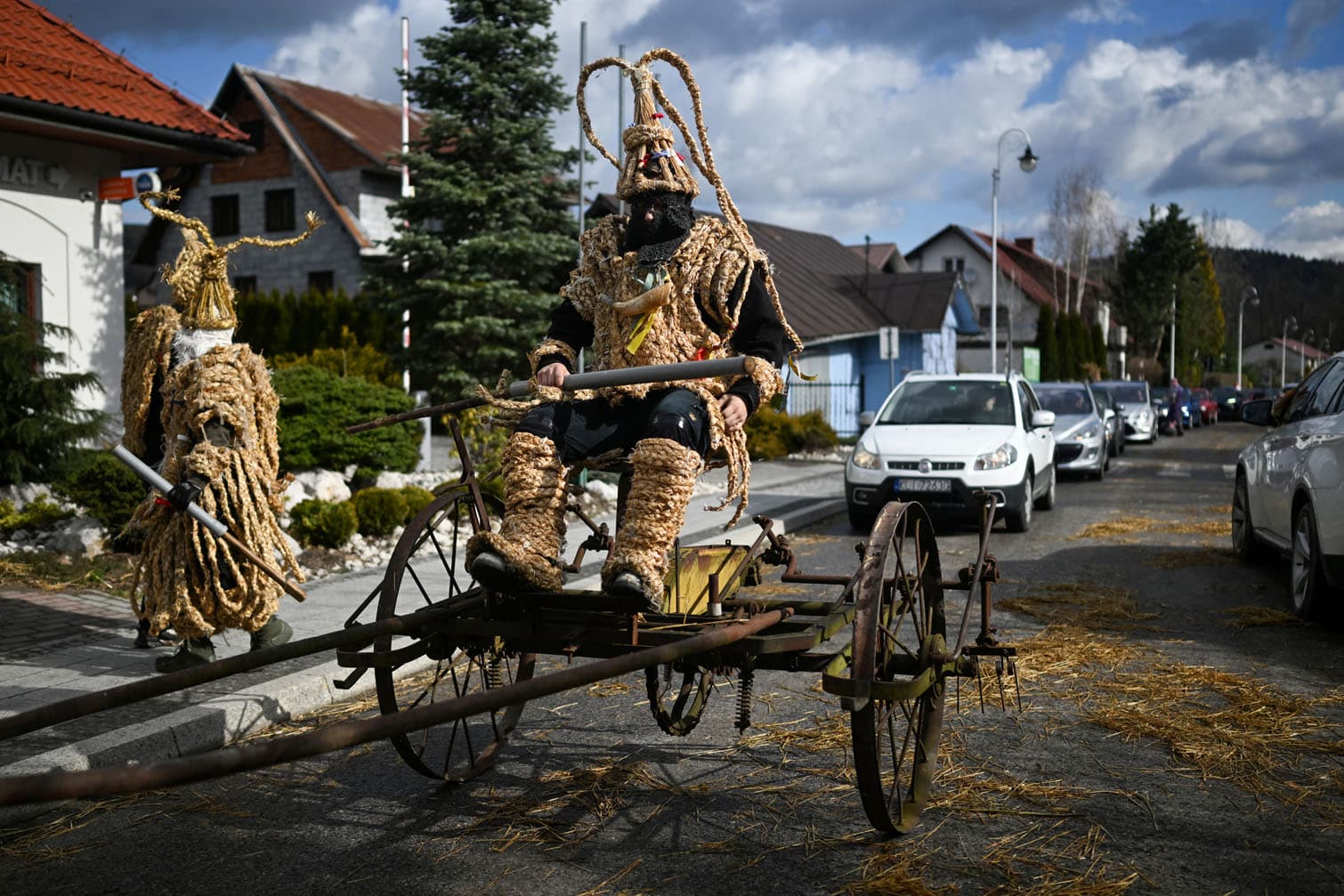 Polish bachelors wearing traditional straw costumes