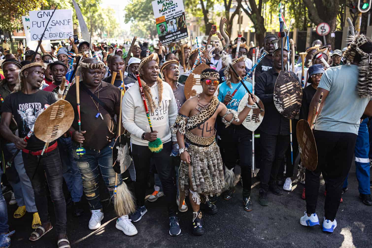 Protesters chant slogans and gesture during a protest march