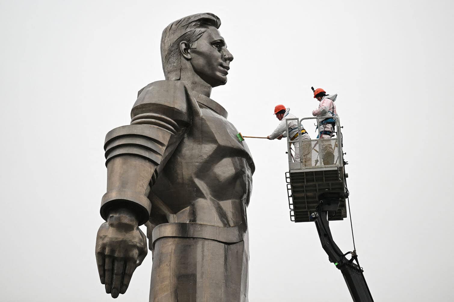 Maintenance workers clean the monument of Soviet cosmonaut Yuri Gagarin