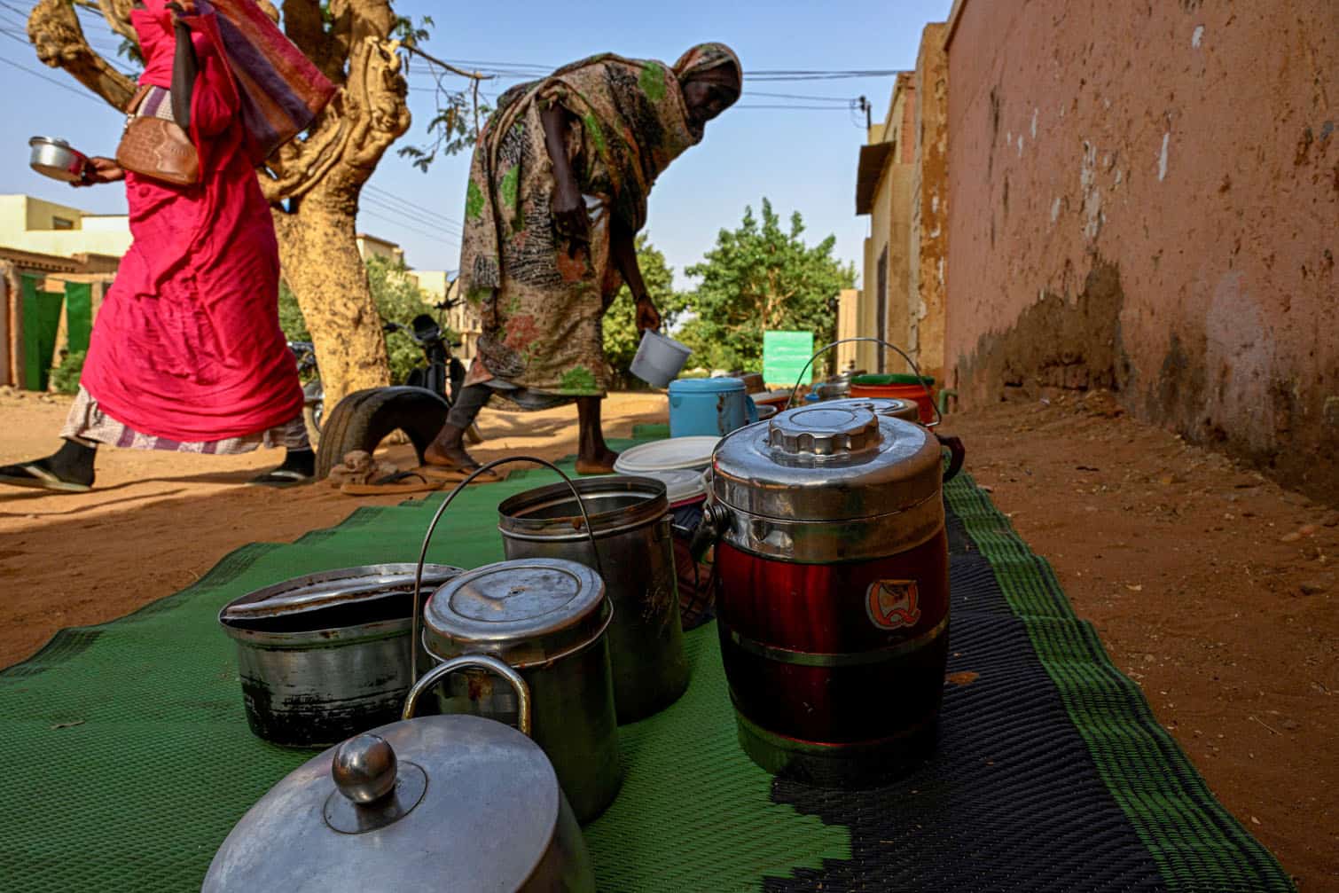 Sudanese women arrange containers filled with free food
