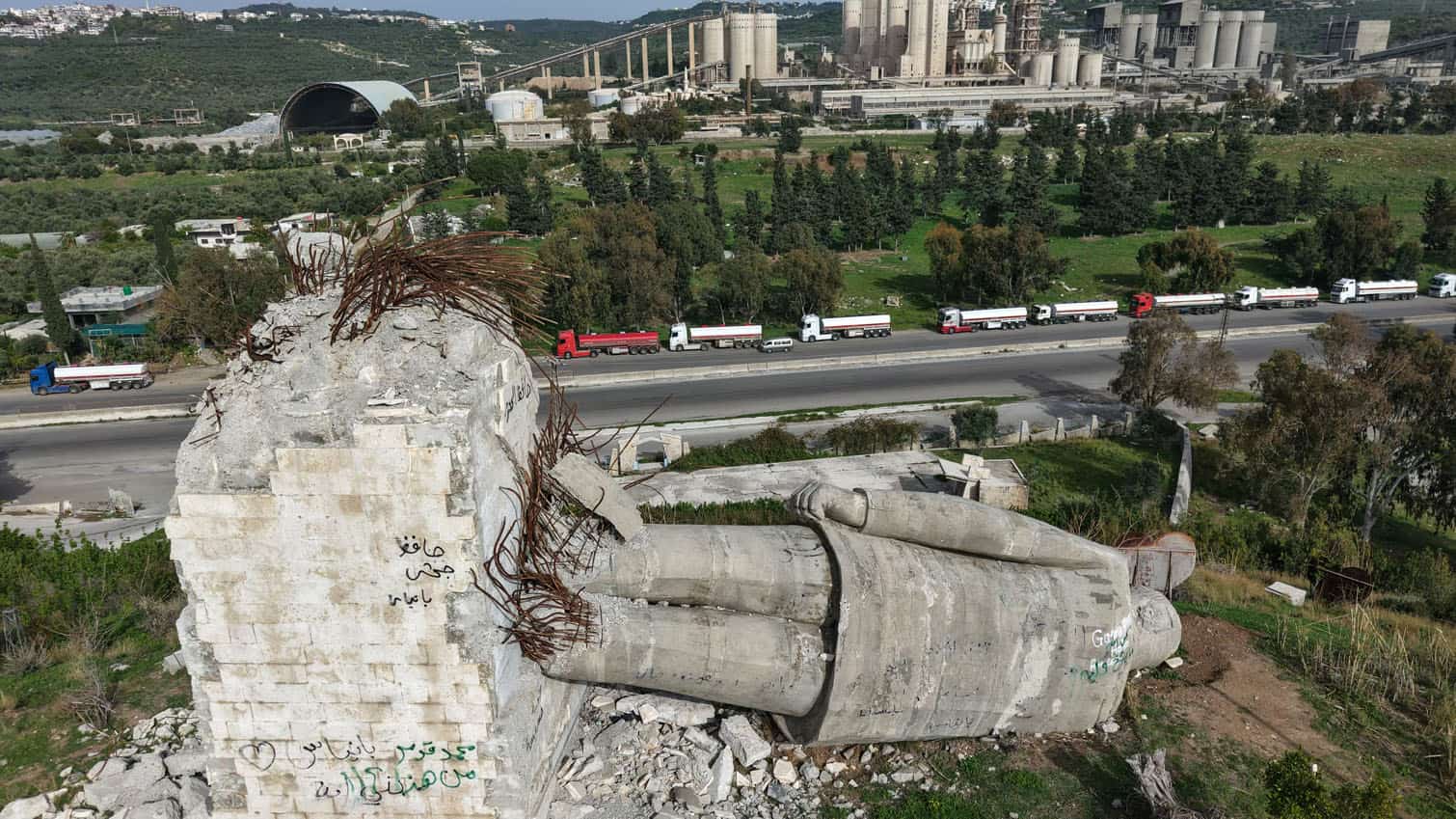 An aerial photograph shows a destroyed statue of the late Syrian president