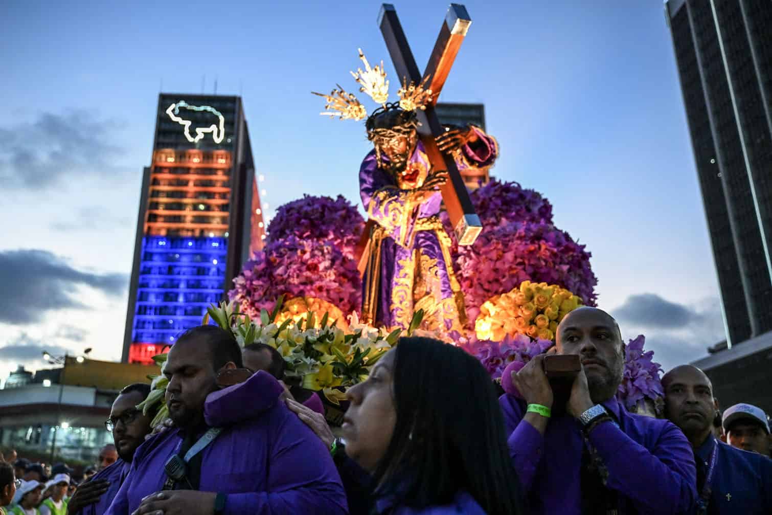 Catholic faithful carry an image of Jesus Christ