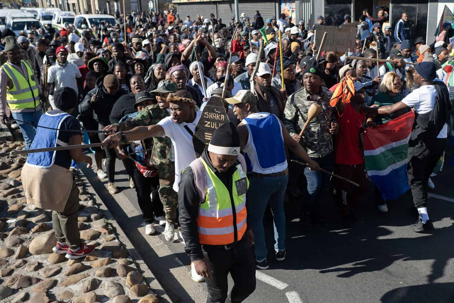 Demonstrators react as they march