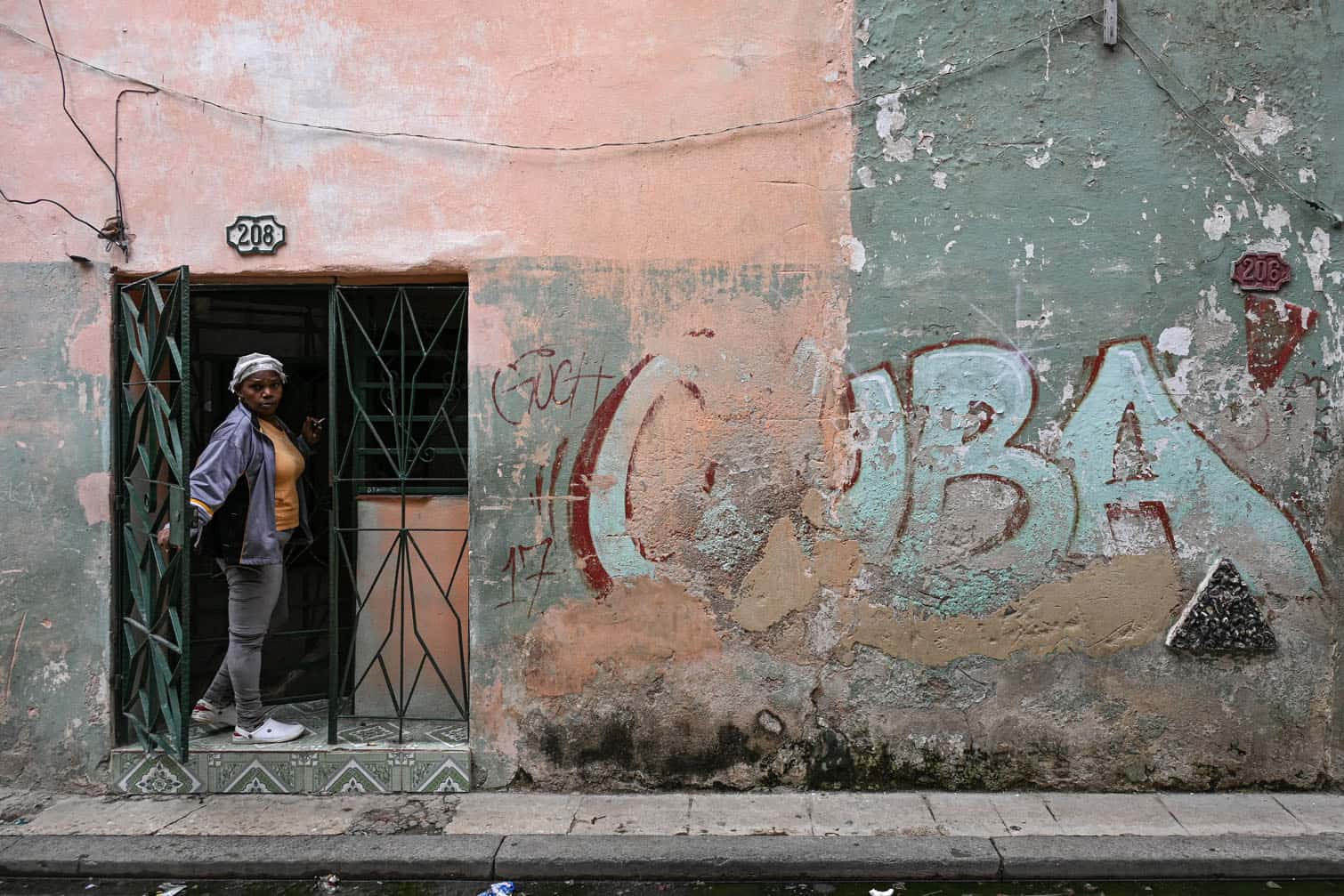A woman peeks out from the doorway of her home