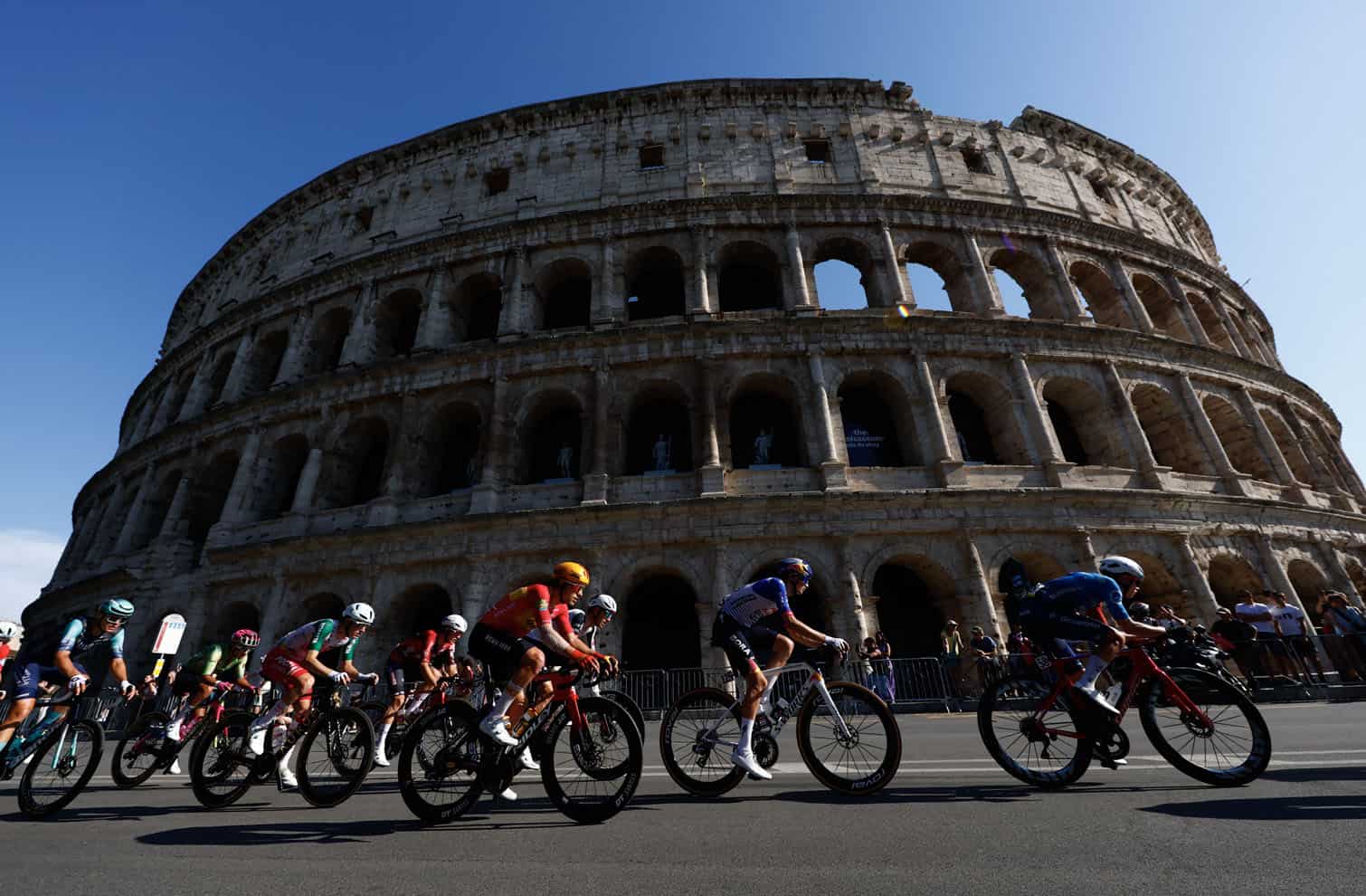 The peloton rides past the Colosseum
