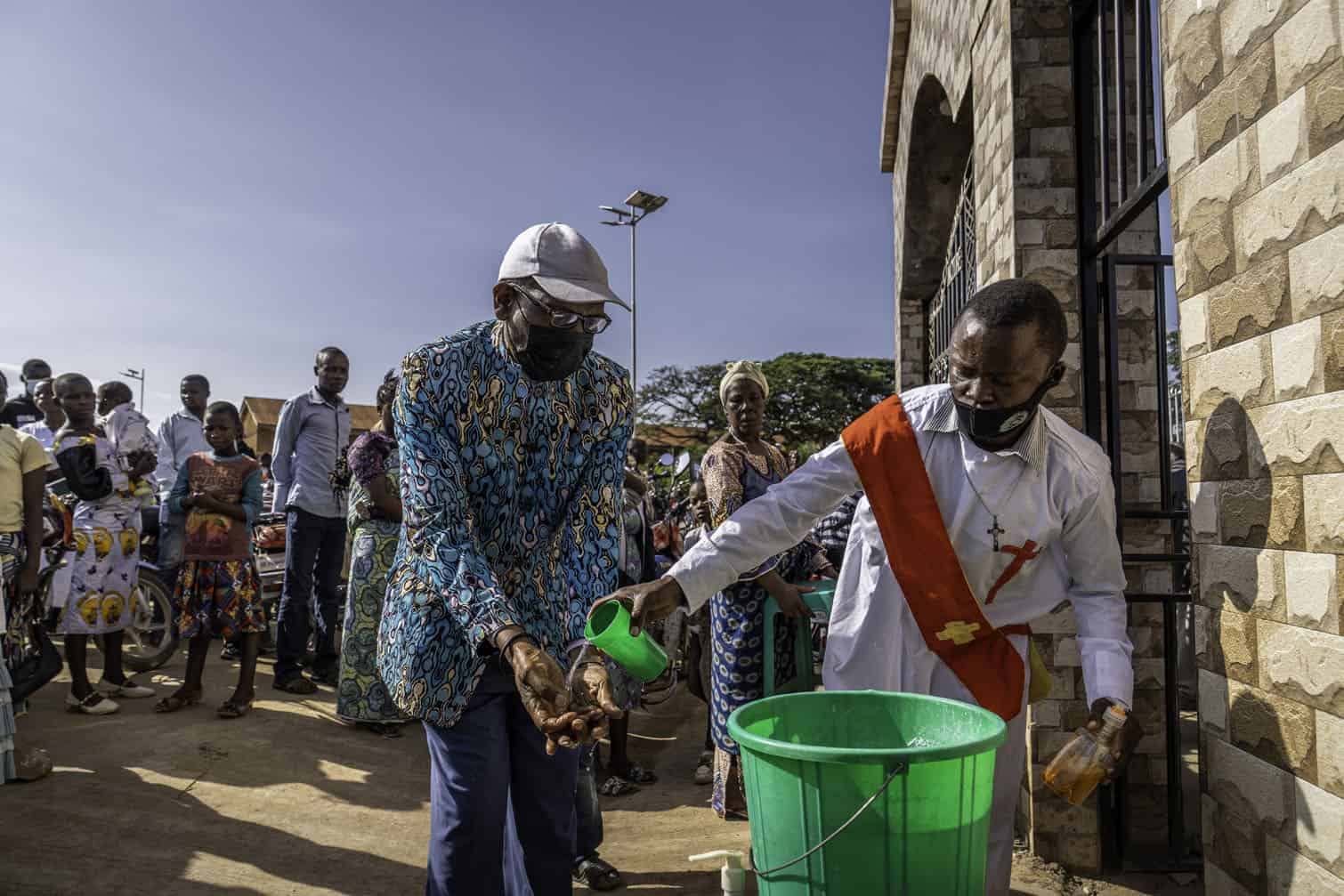 A deacon helps a parishioner wash his hands