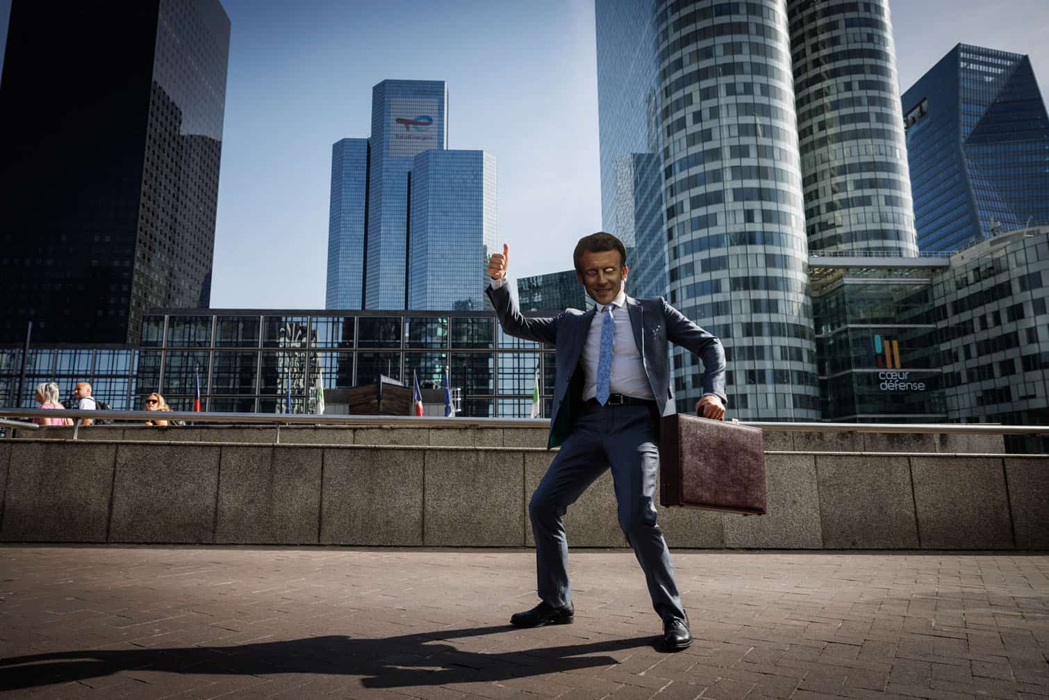 A person with a mask depicting France's President Emmanuel Macron