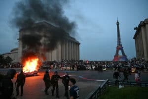 A car is set ablaze as PSG supporters celebrate