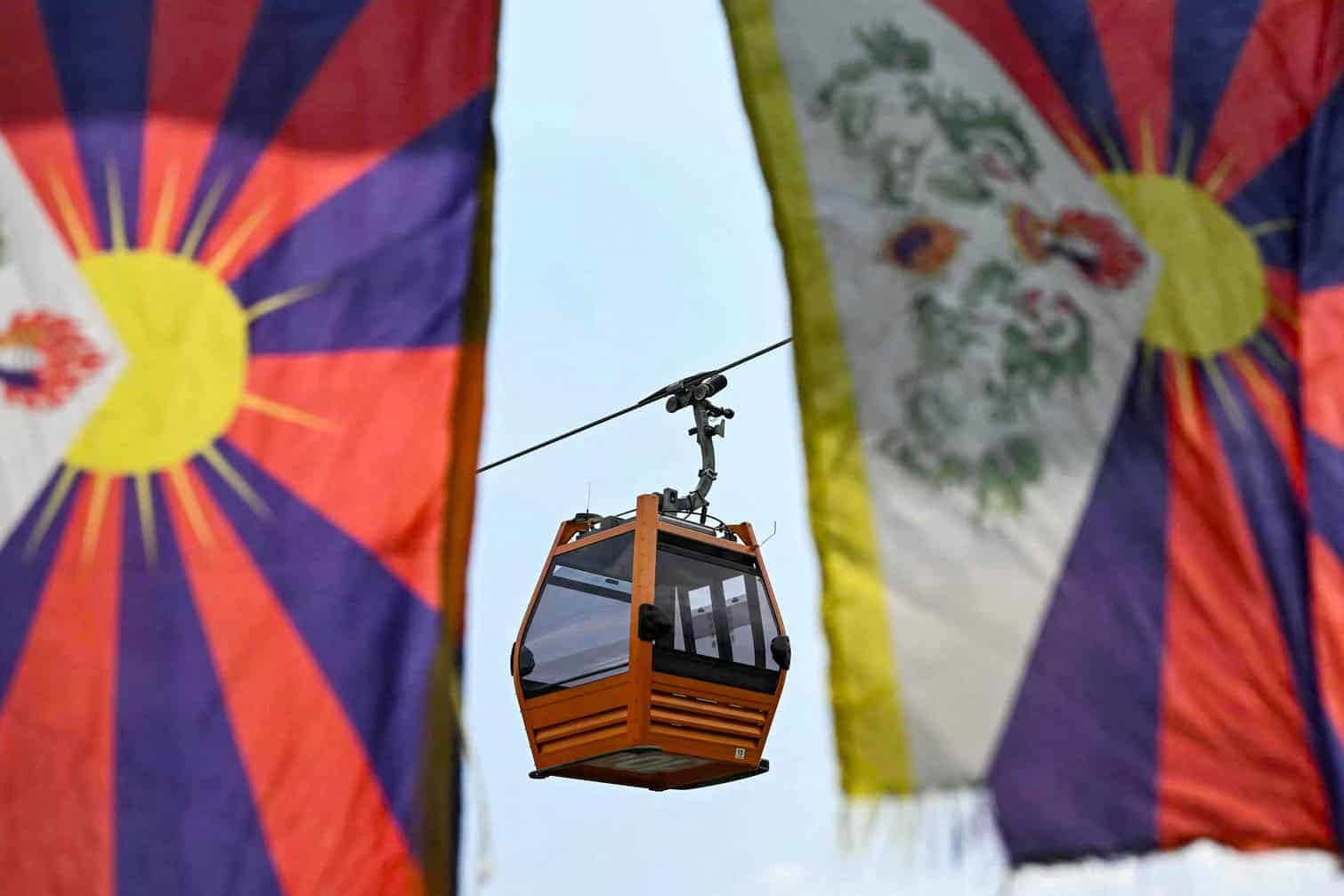 A cable car is pictured behind Tibetan flags