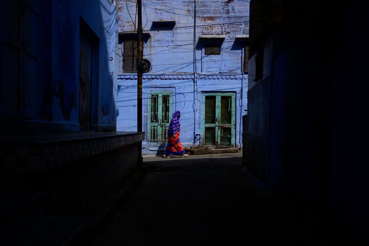 A woman walks past the iconic blue-colored houses