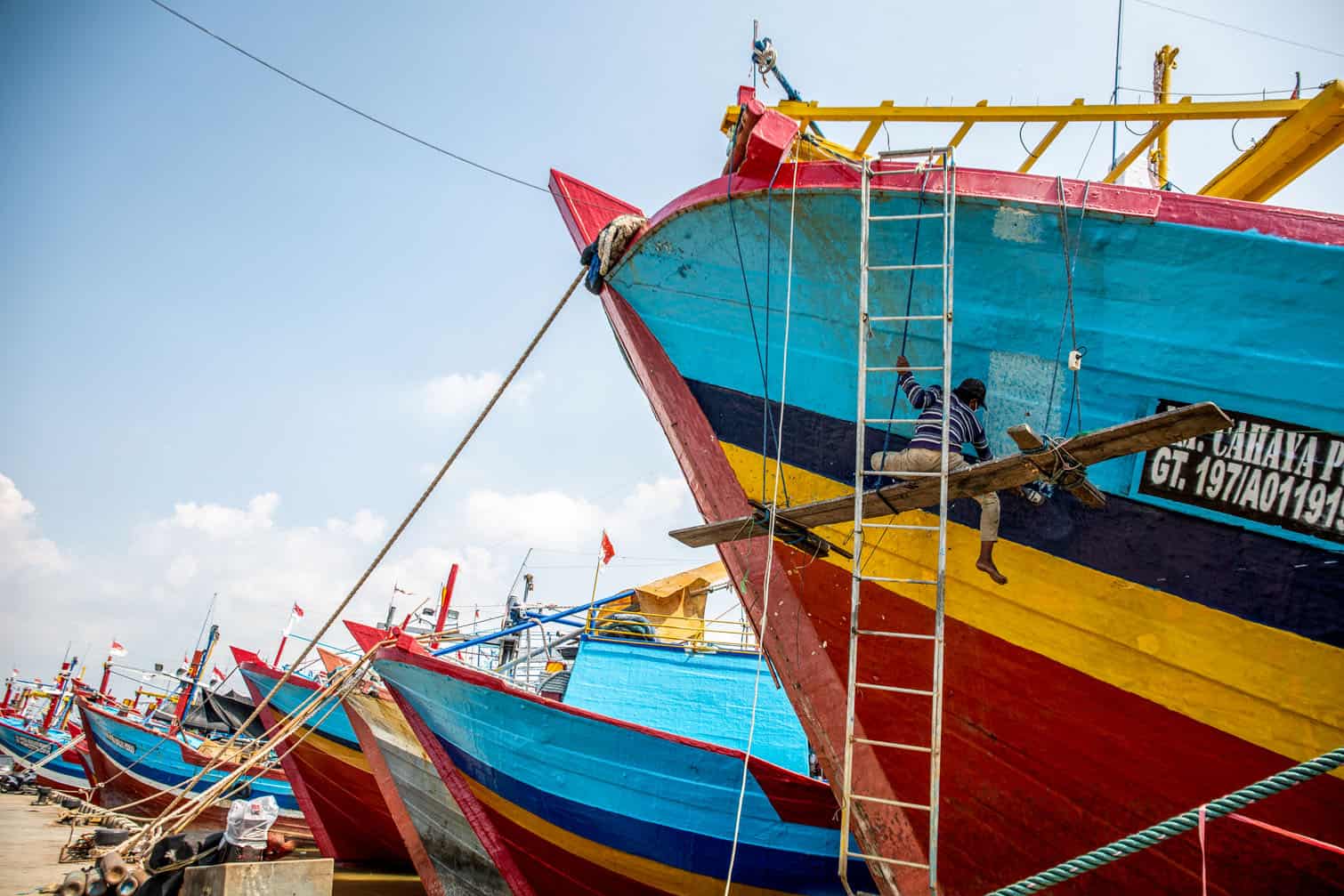 A man repaints a fishing boat