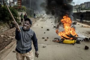 A protester reacts on a road blocked with a burning barricade