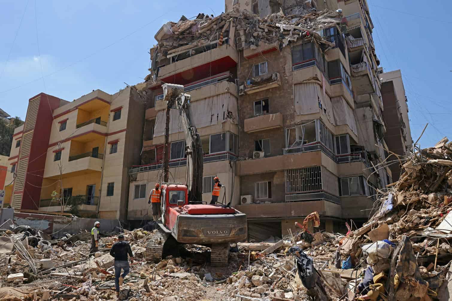 First responders inspect the rubble of a collapsed building