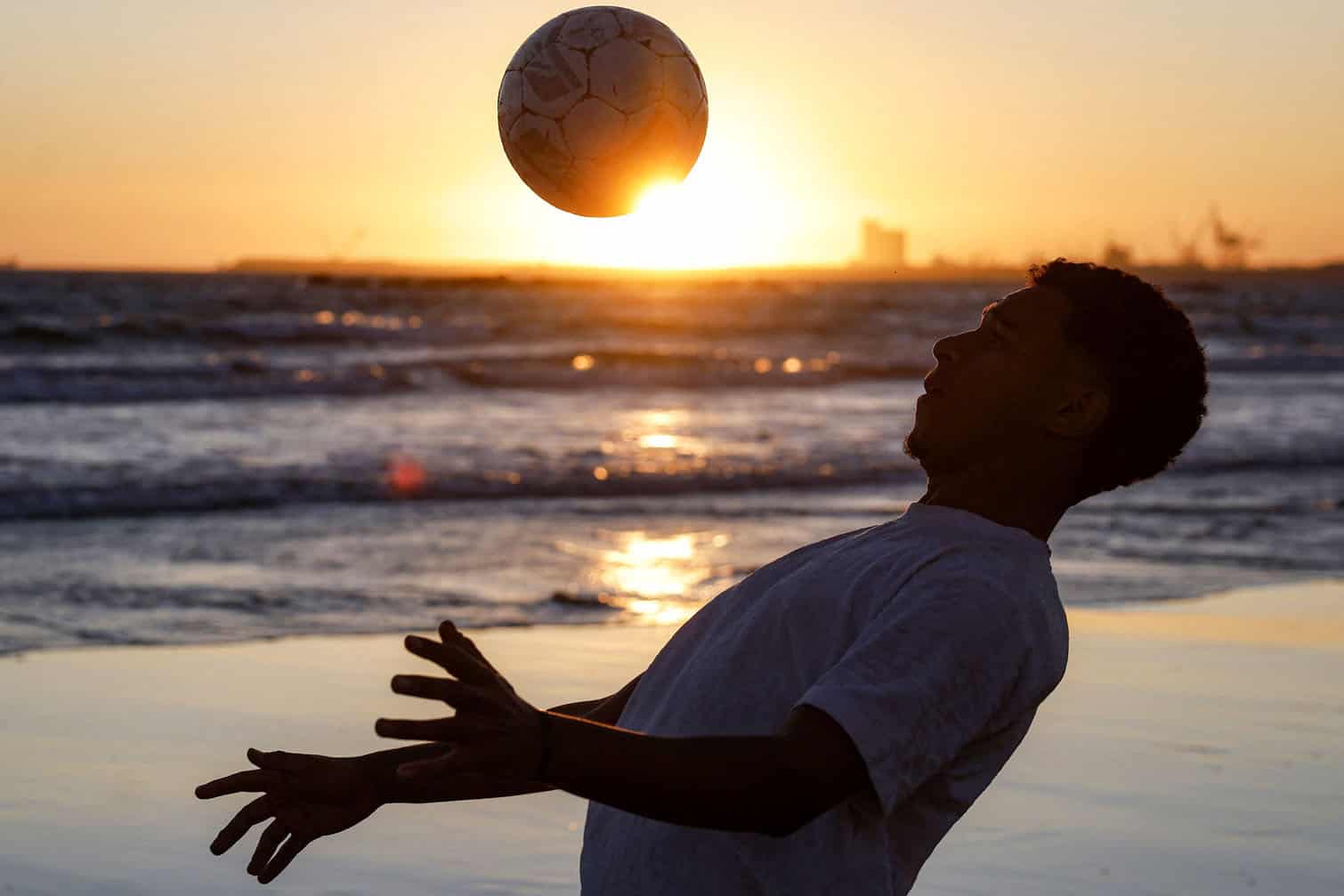 A youth practises stunts with a football
