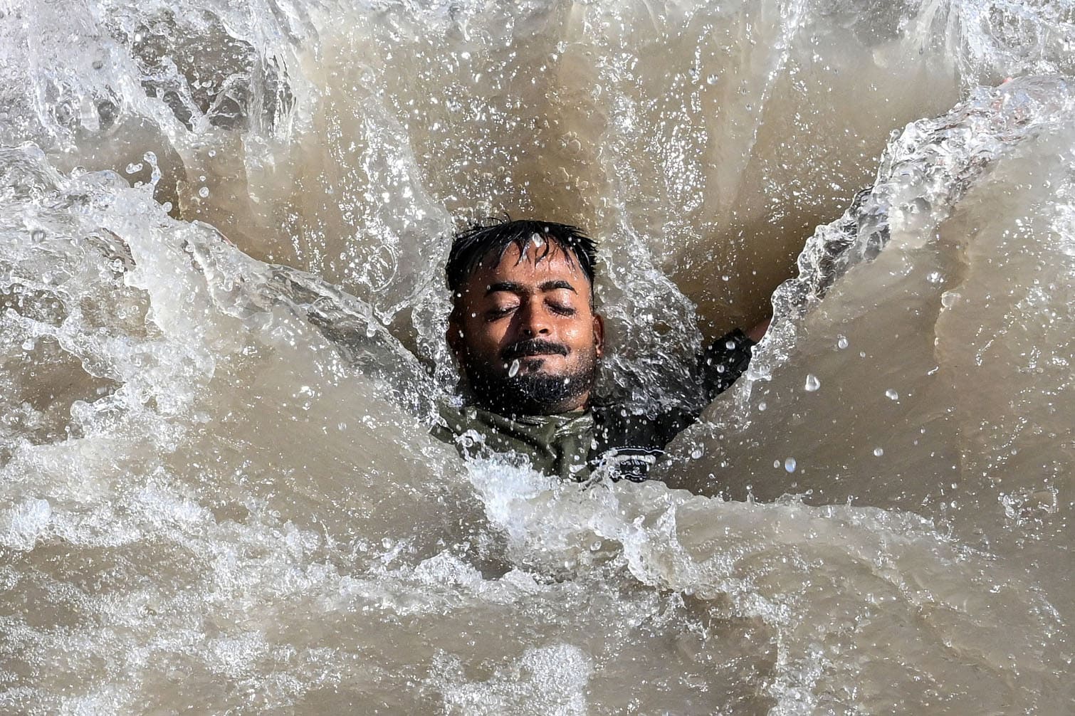 A man swims in a canal to cool off