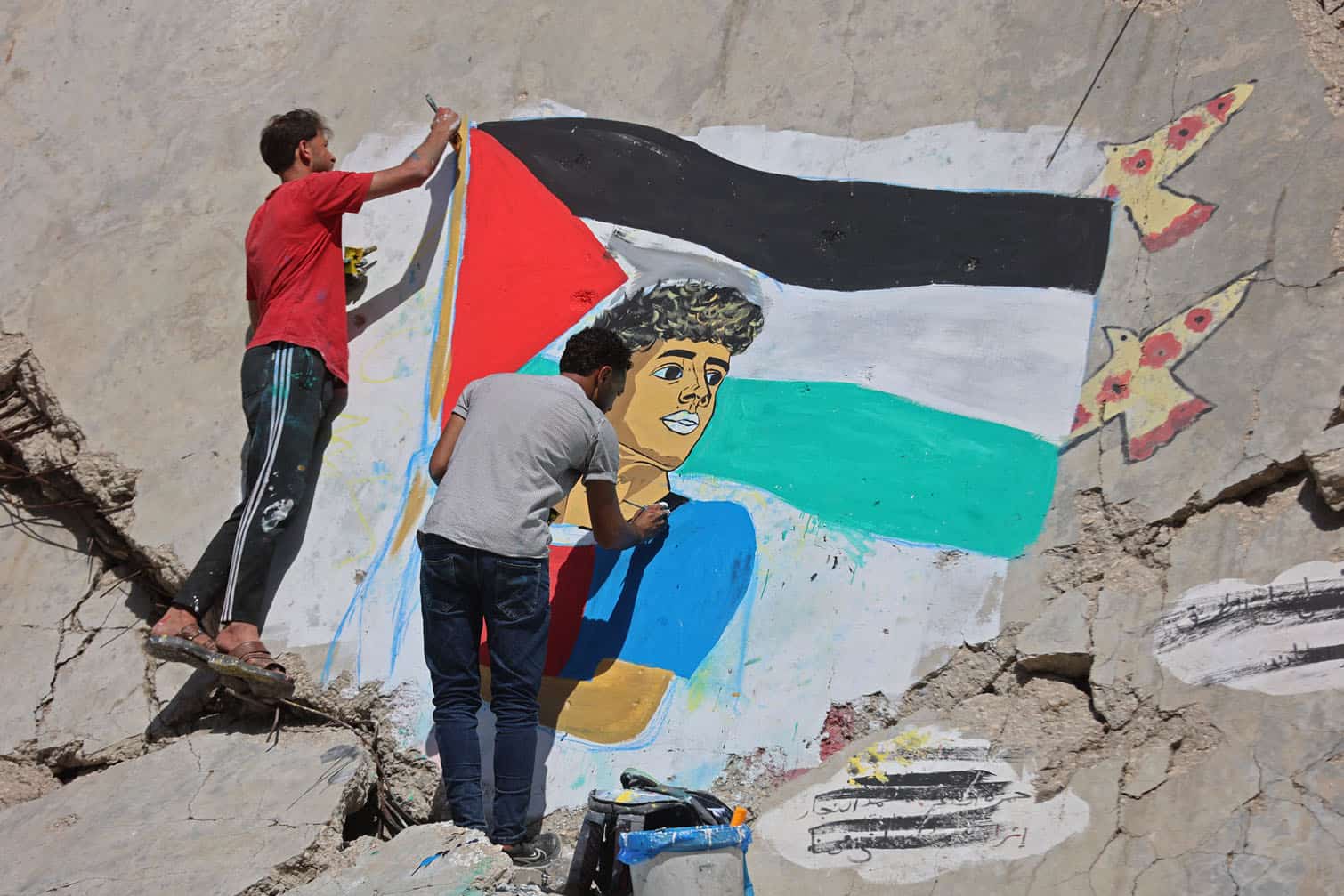 Palestinian artists paint a mural