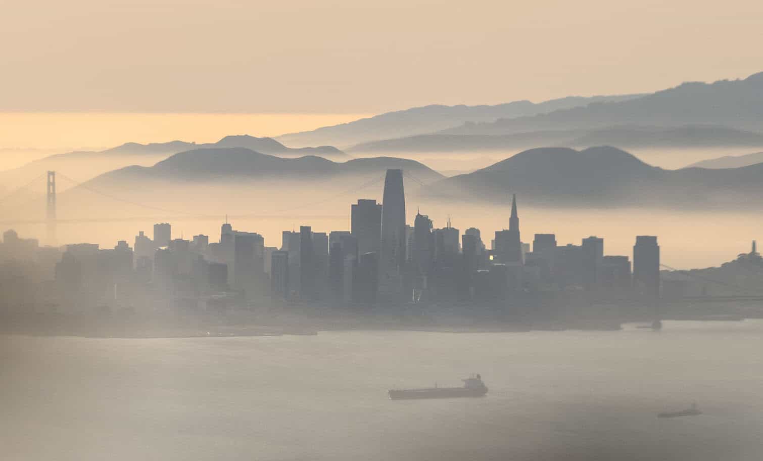 An aerial view shows the backlit skyline of San Francisco