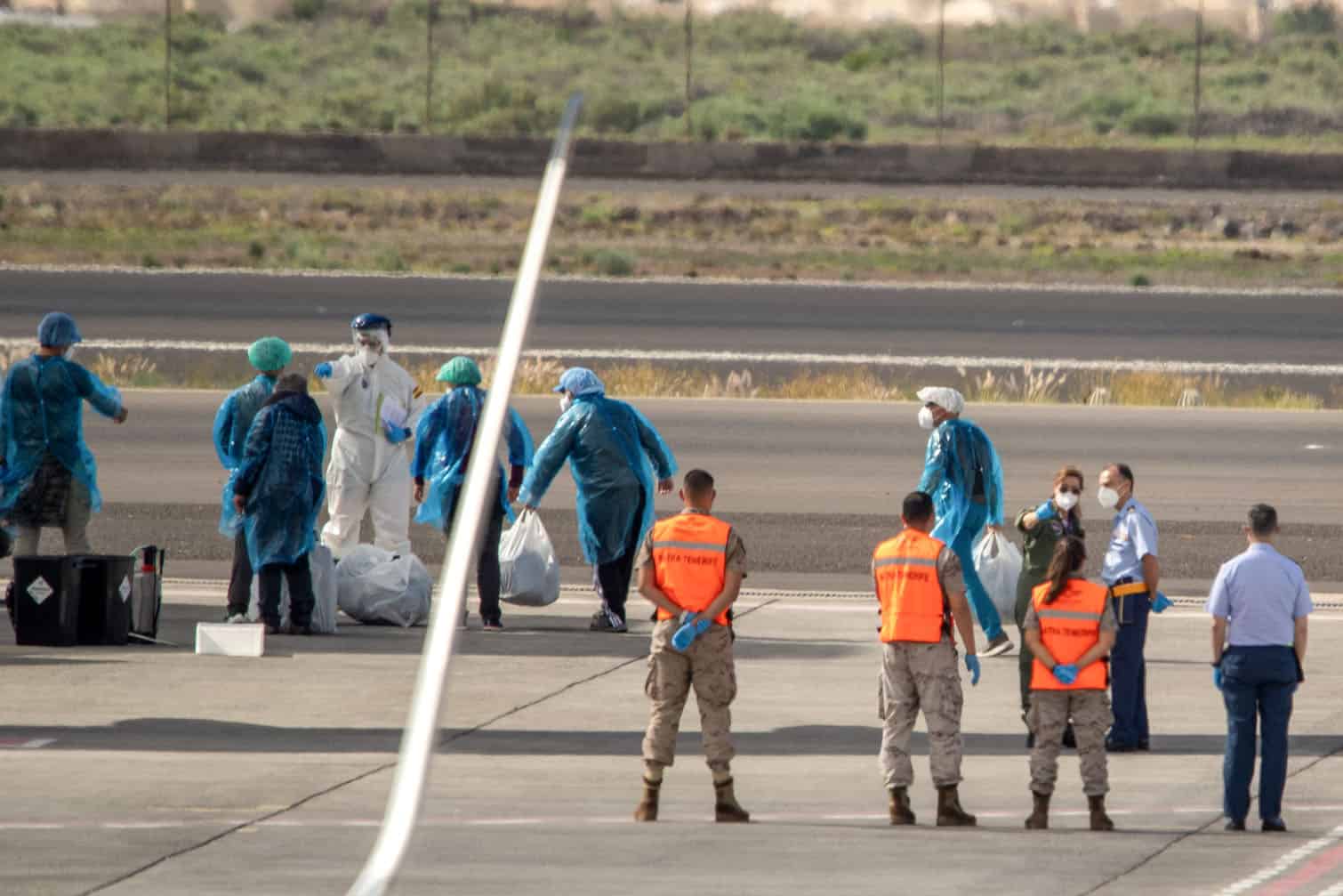 Spanish evacuees wearing blue protective suits